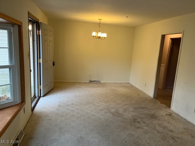 11423 Colburn Road Painesville, OH 44077 - Photo 6 of 16 Carpeted empty room featuring an inviting chandelier
