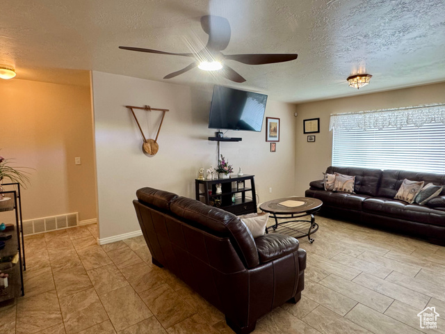 445 Topaz Boulevard, Unit 10 Delta, UT 84624 - Photo 8 of 28 Living area with ceiling fan, a textured ceiling, and baseboards