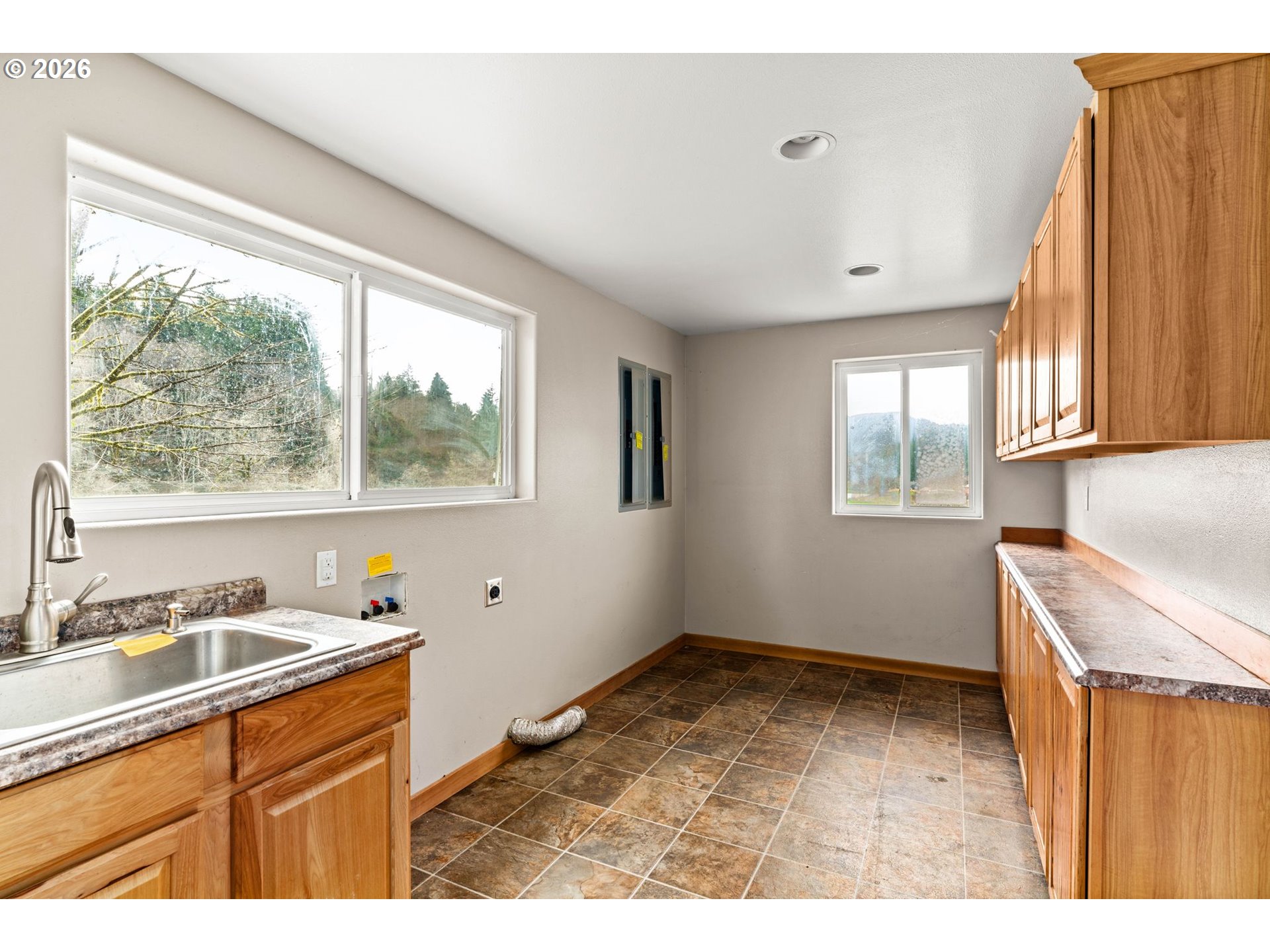 7470 Maple Creek Road Westlake, OR 97493 - Photo 13 of 33 a kitchen with a window wooden cabinets and a sink