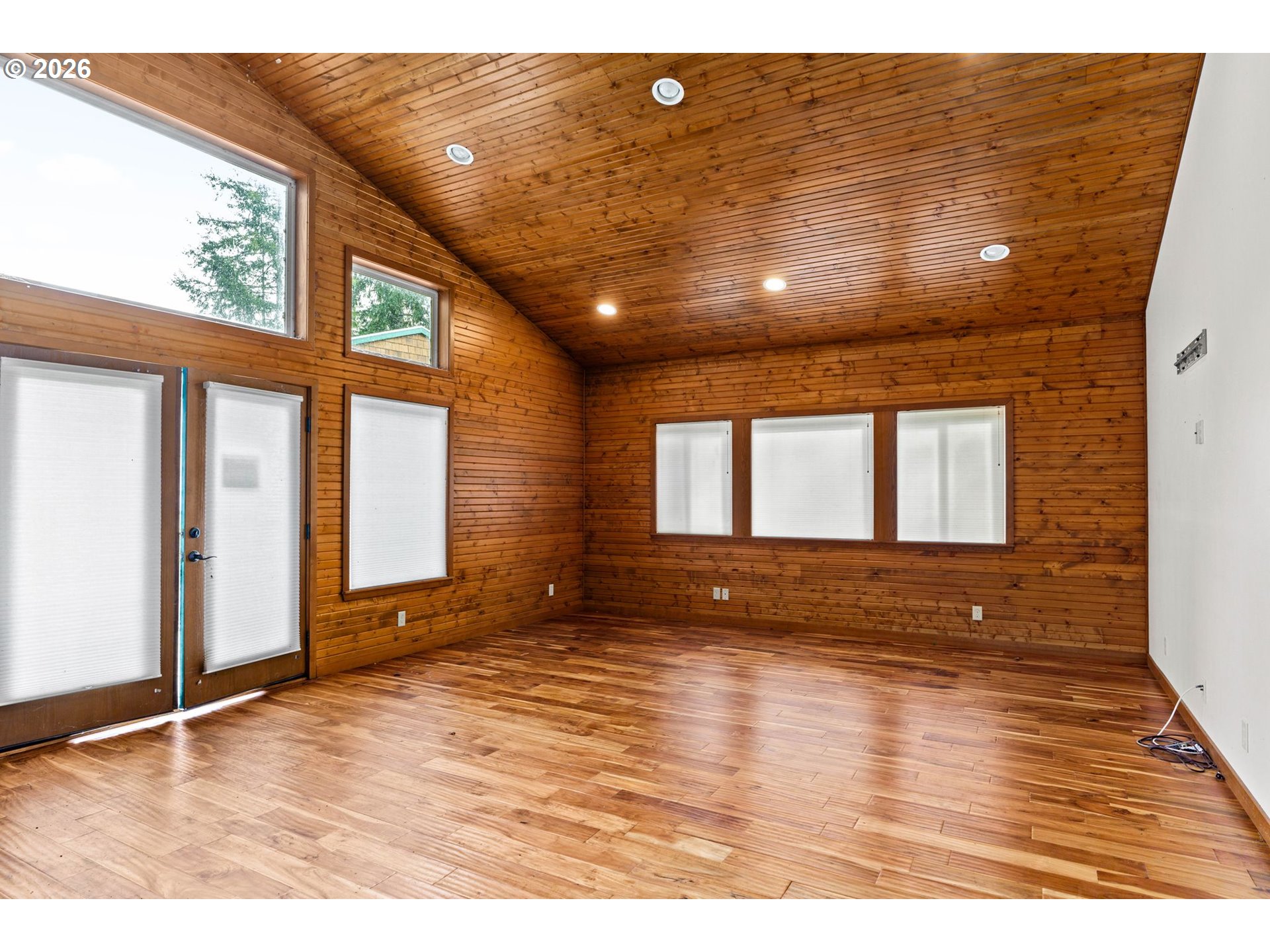7470 Maple Creek Road Westlake, OR 97493 - Photo 18 of 33 a view of an empty room with wooden floor and a window