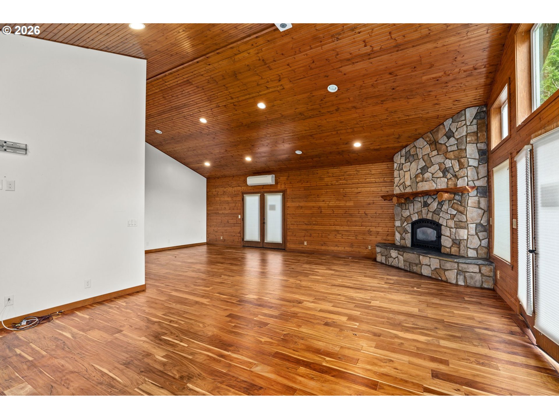 7470 Maple Creek Road Westlake, OR 97493 - Photo 6 of 33 a view of empty room with wooden floor and fireplace