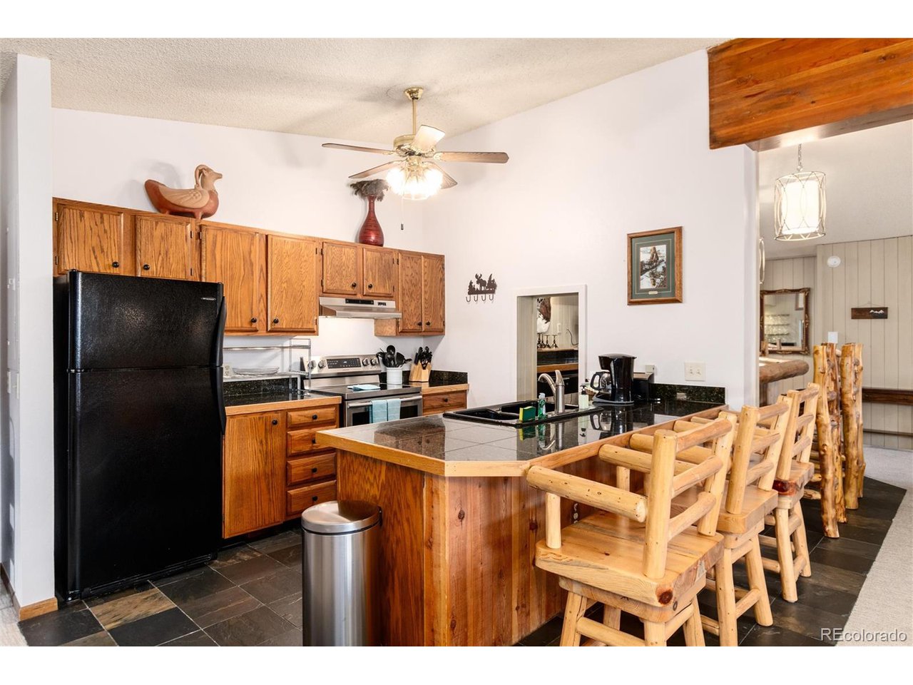 490 Kings Crossing Road, Unit 631 Winter Park, CO 80482 - Photo 17 of 43 a kitchen with stainless steel appliances a stove a refrigerator a sink a dining table and chairs