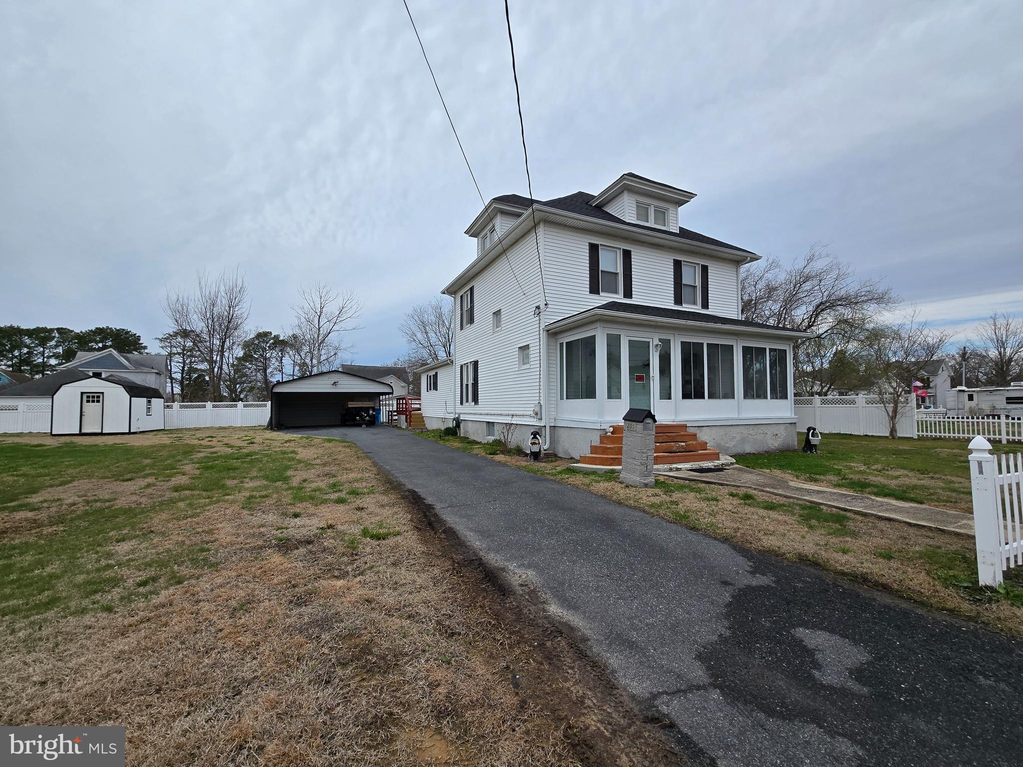 205 Myrtle Street Crisfield, MD 21817 - Photo 1 of 56 a front view of a house with a yard table and chairs