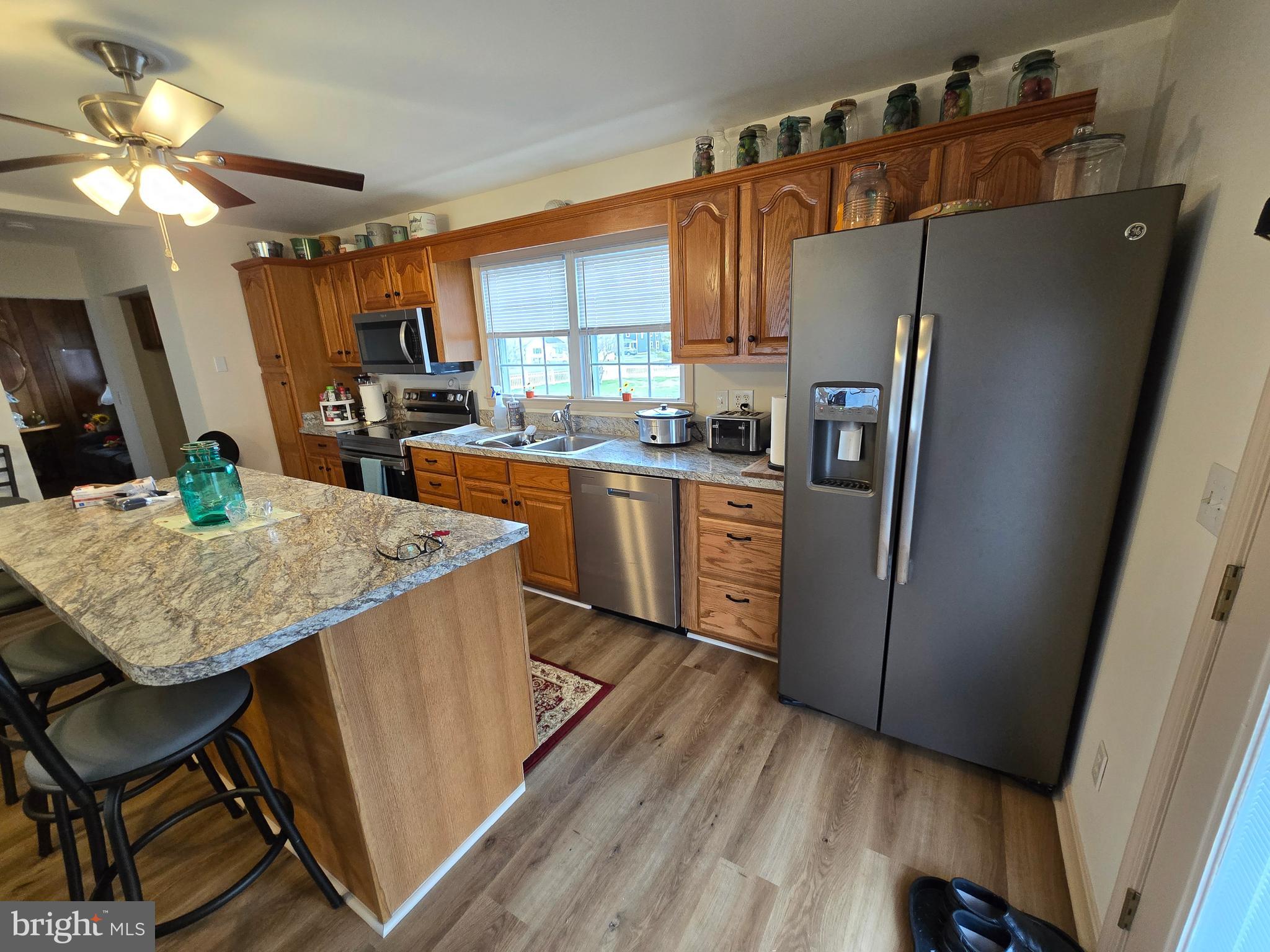 205 Myrtle Street Crisfield, MD 21817 - Photo 14 of 56 a kitchen with granite countertop a refrigerator a stove a sink dishwasher and wooden cabinets