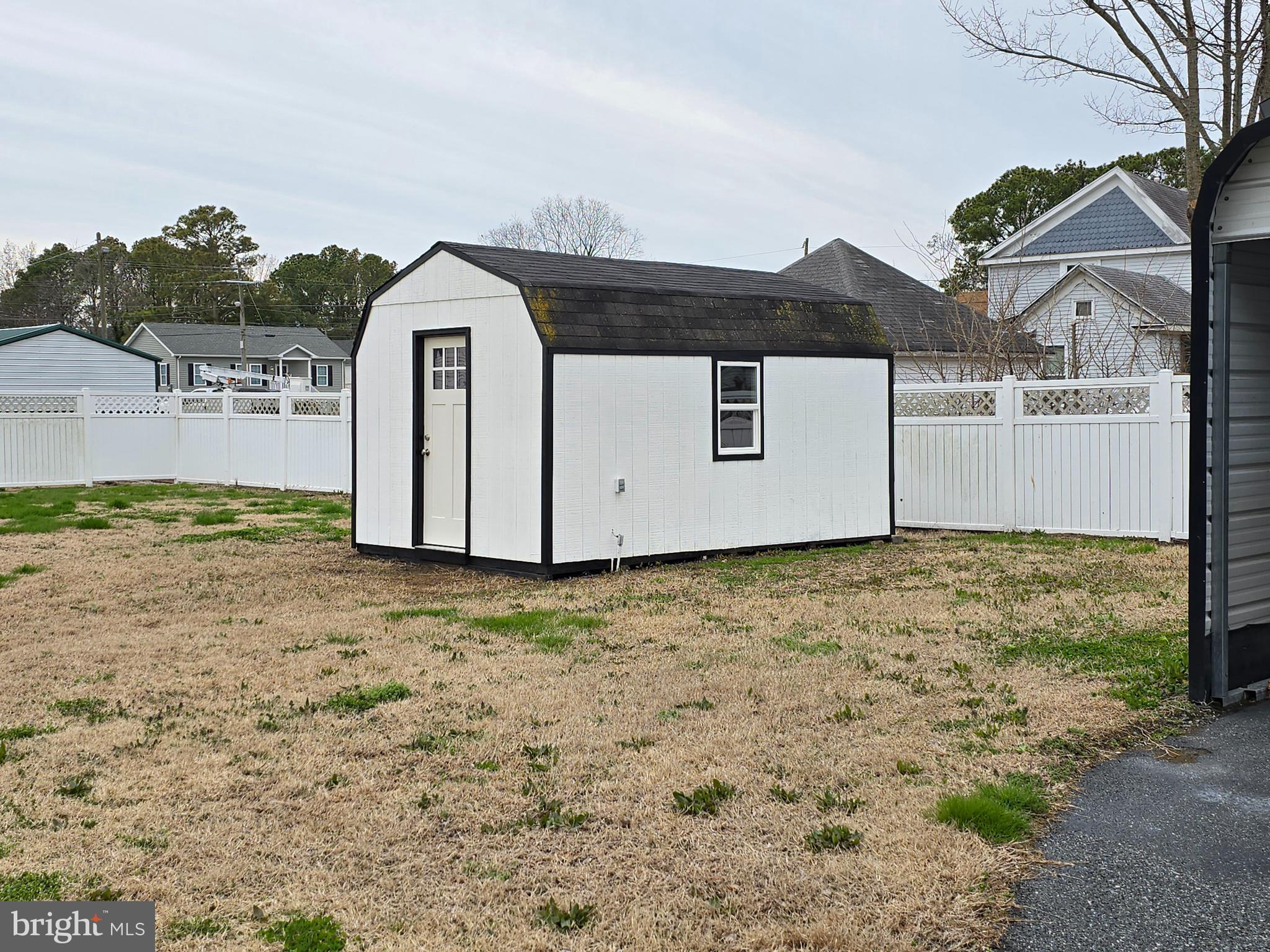 205 Myrtle Street Crisfield, MD 21817 - Photo 32 of 56 a view of a backyard with large trees and a wooden fence