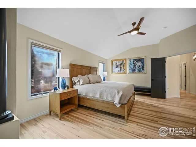 a spacious bedroom with a bed and wooden floor