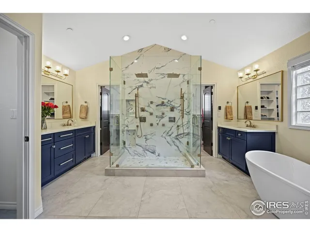 a spacious bathroom with a double vanity sink toilet mirror and bathtub