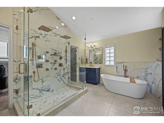 a spacious bathroom with a tub sink shower and mirror