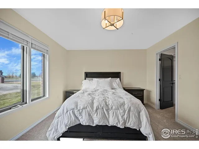 a bedroom with a bed and painting on the wall