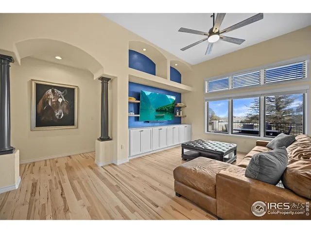 a living room with furniture floor to ceiling window and wooden floor
