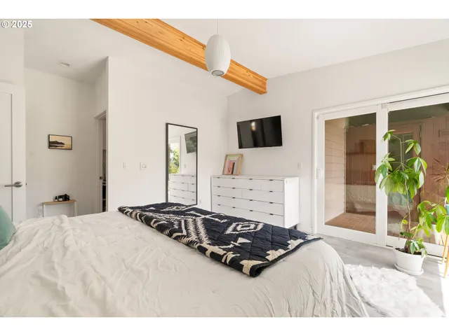 a bedroom with a bed and a large window with outer view