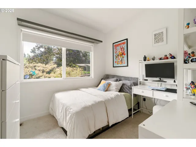 a bedroom with a bed a table and a large window