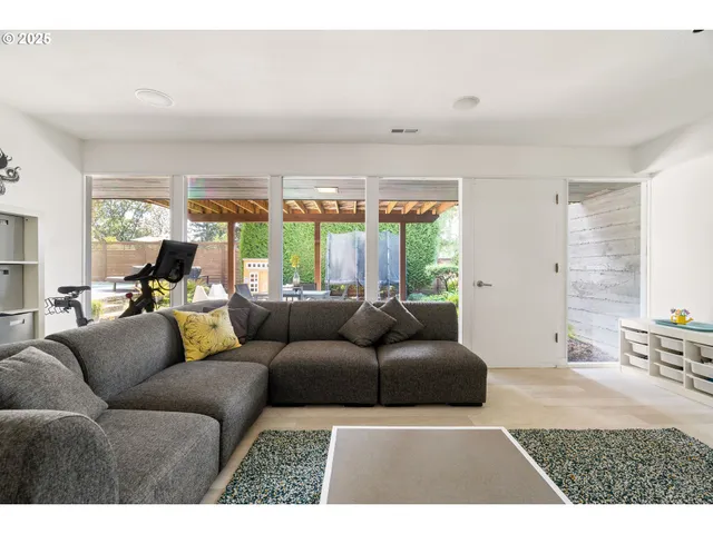 a living room with furniture a large window with kitchen view
