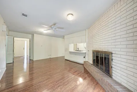 a view of empty room with wooden floor and fireplace