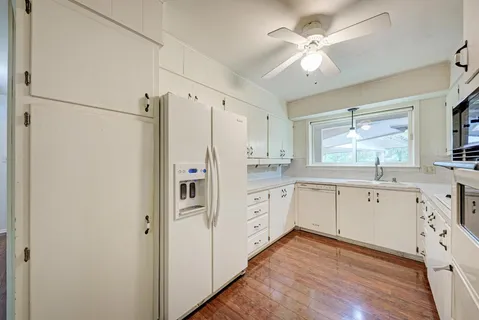 a kitchen with cabinets stainless steel appliances a sink and a window