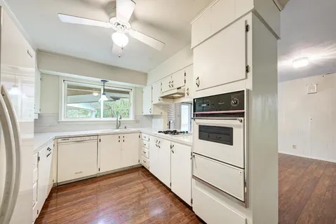 a kitchen with white cabinets and white appliances
