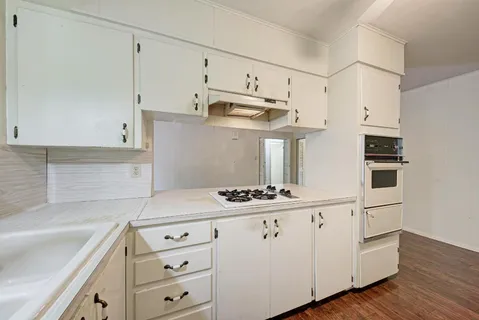 a kitchen with cabinets and wooden floor