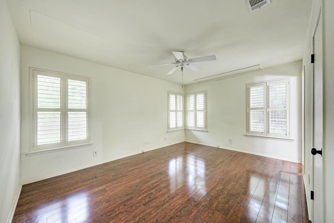 2500 Spring Creek Drive Austin, TX 78704 - Photo 19 of 40 a view of an empty room with wooden floor and a window