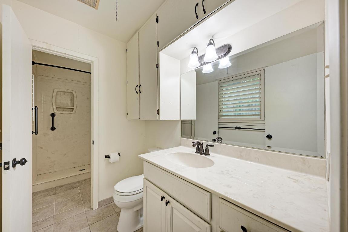 2500 Spring Creek Drive Austin, TX 78704 - Photo 22 of 40 a bathroom with a sink a toilet and a mirror