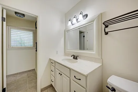 a bathroom with a sink a toilet and a mirror