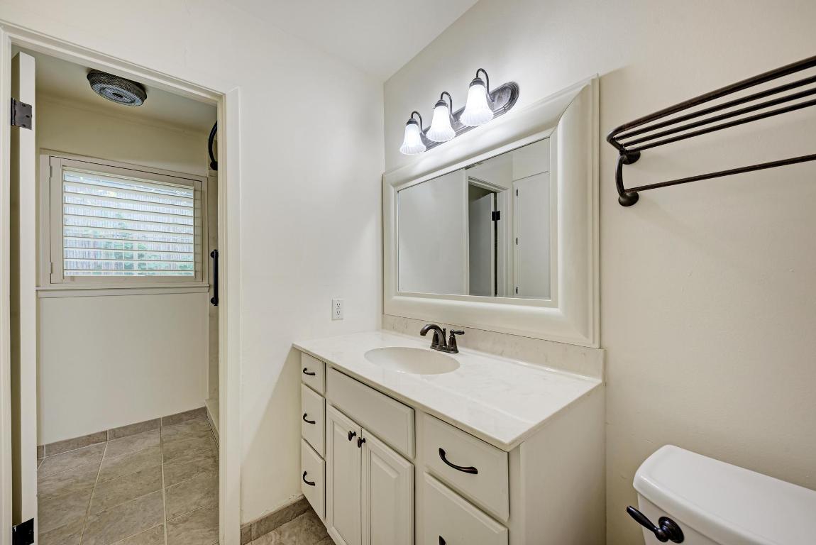 2500 Spring Creek Drive Austin, TX 78704 - Photo 24 of 40 a bathroom with a sink a toilet and a mirror