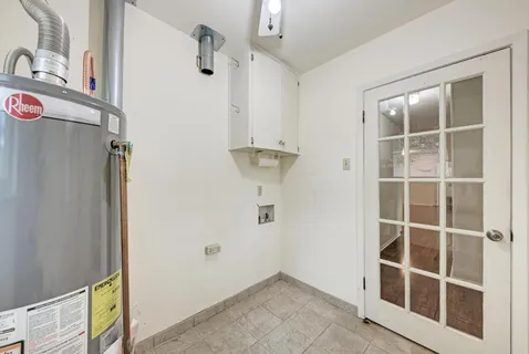 a view of an empty room with cabinet and a window