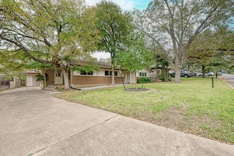 front view of a house with a yard and an trees
