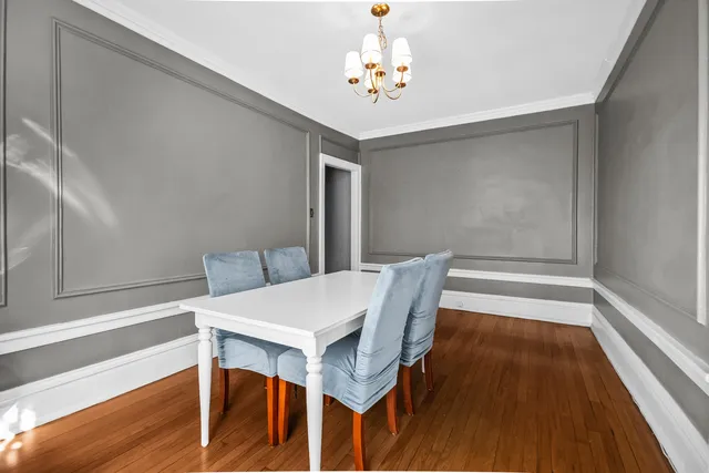 a view of a dining room with furniture wooden floor and chandelier