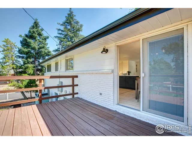 a backyard of a house with table and chairs plants and large trees