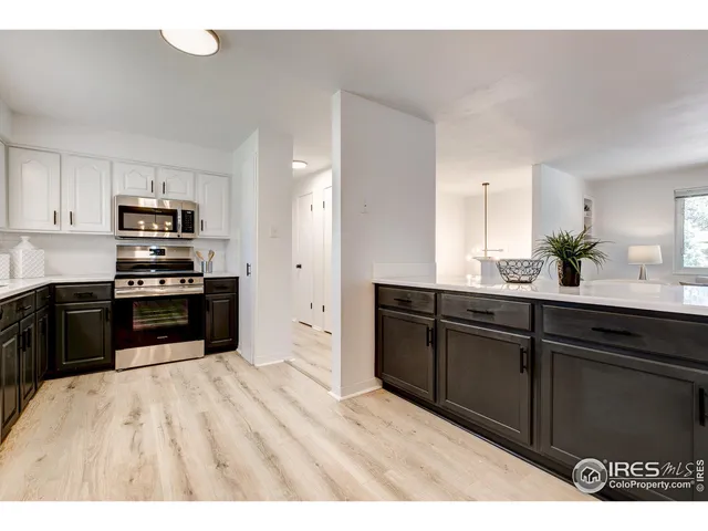 a kitchen with granite countertop a refrigerator and a stove top oven