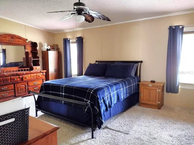 a bedroom with a bed and a flat tv screen on the dresser