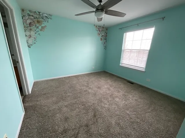 en empty room with windows and ceiling fan