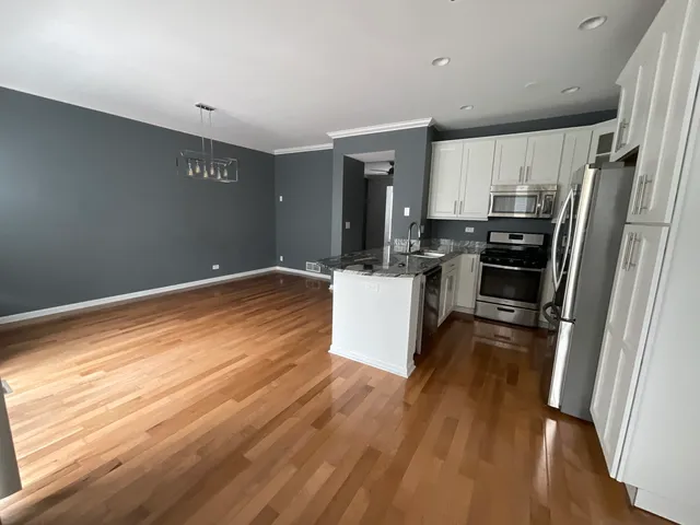 a kitchen with a refrigerator a stove top oven and a sink