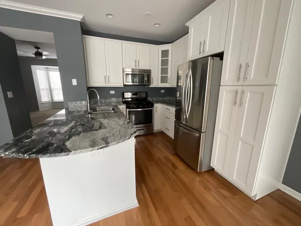 a kitchen with stainless steel appliances granite countertop a refrigerator a stove a sink and a refrigerator