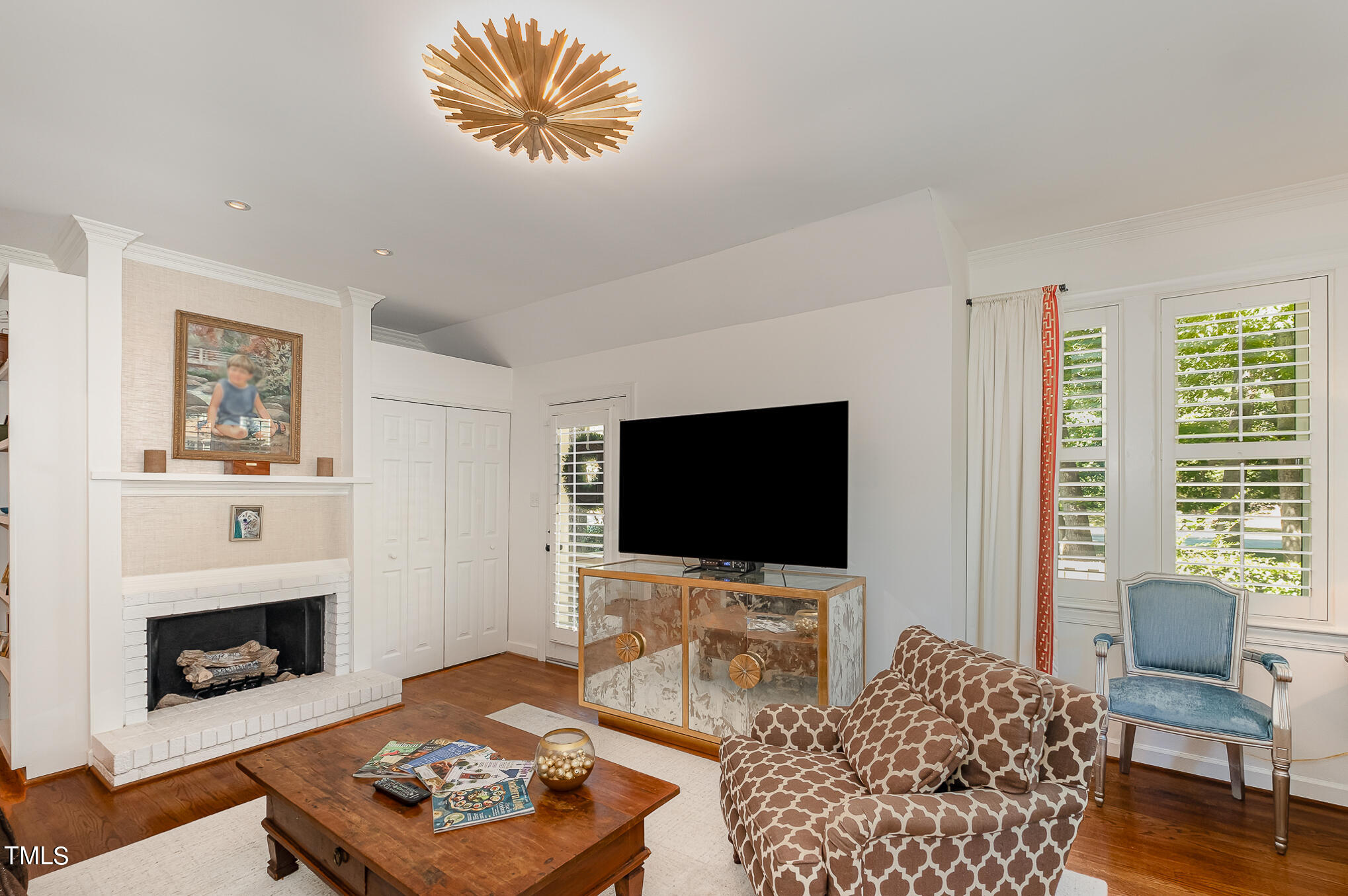 1715 Falls Church Road Raleigh, NC 27609 - Photo 8 of 19 a living room with furniture a flat screen tv and a fireplace
