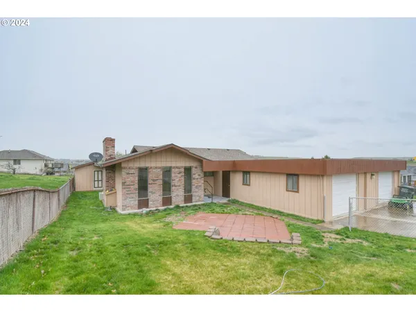 a view of a house with a yard and table