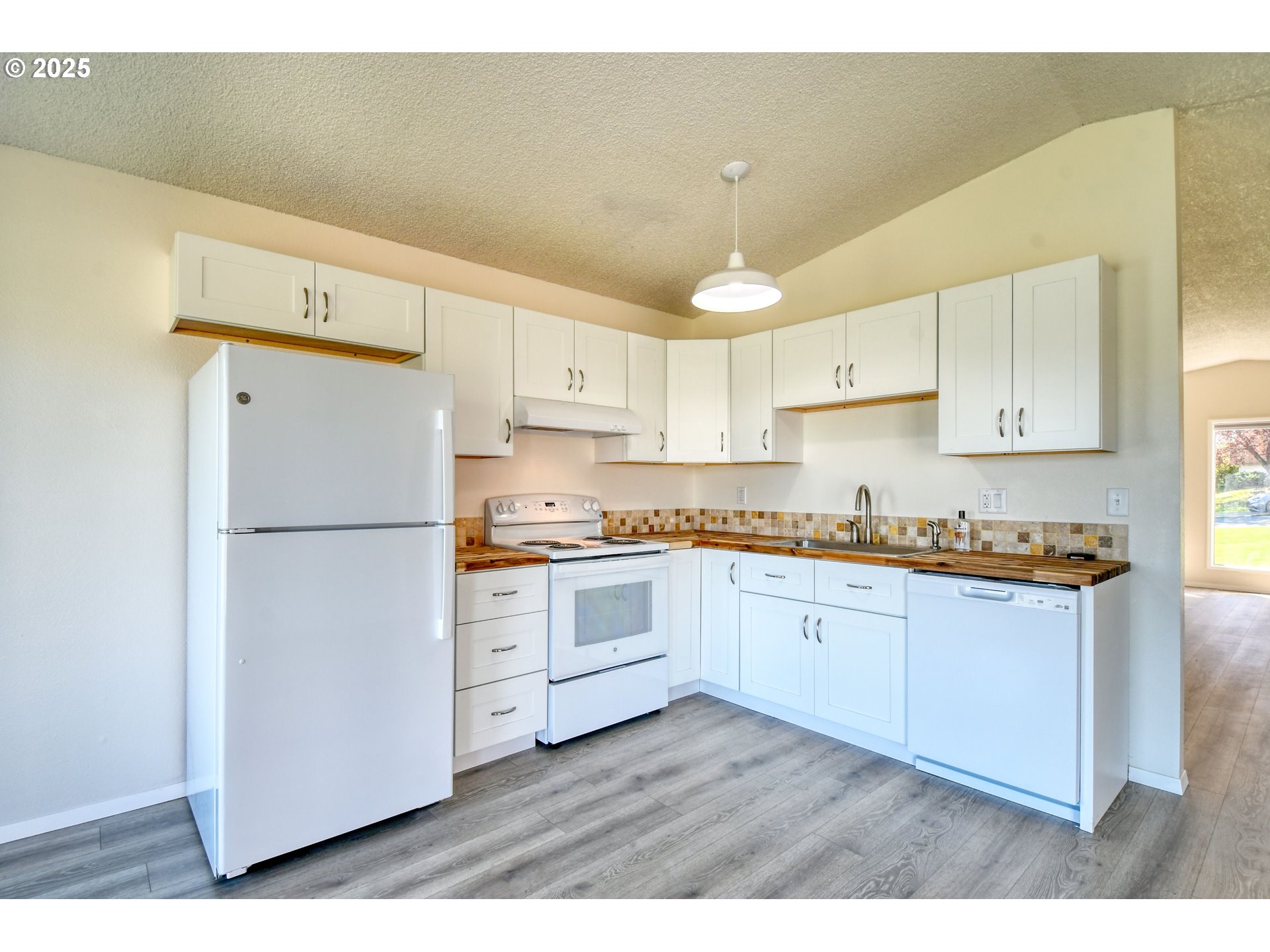 1209 Zeta Court Pendleton, OR 97801 - Photo 33 of 48 a kitchen with granite countertop a refrigerator oven a sink and white cabinets