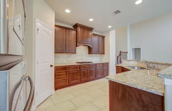 a kitchen with stainless steel appliances granite countertop a sink refrigerator and cabinets