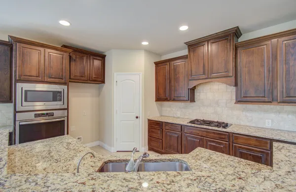 a kitchen with kitchen island granite countertop a stove cabinets and refrigerator