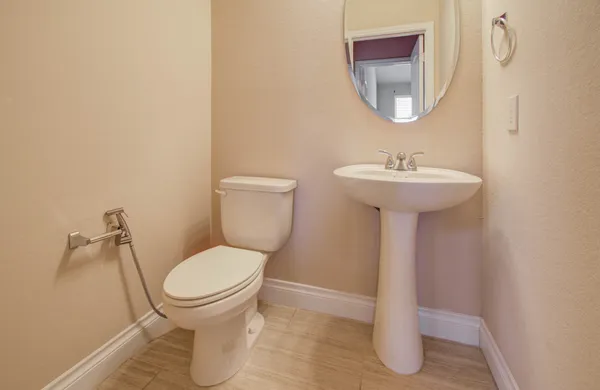 a bathroom with a toilet sink and mirror