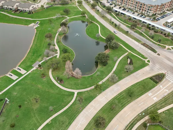 an aerial view of a residential houses with outdoor space and a lake view