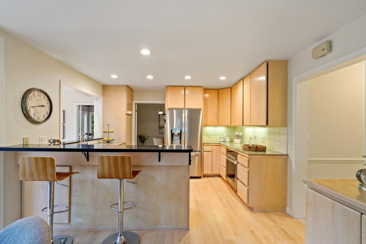 176 Swett Road Woodside, CA 94062 - Photo 15 of 39 a open kitchen with stainless steel appliances granite countertop a stove top oven a sink a dining table and chairs with wooden floor