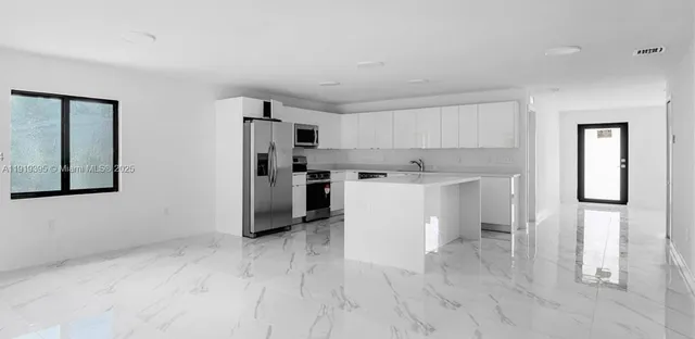 a kitchen with stainless steel appliances a refrigerator sink and cabinets