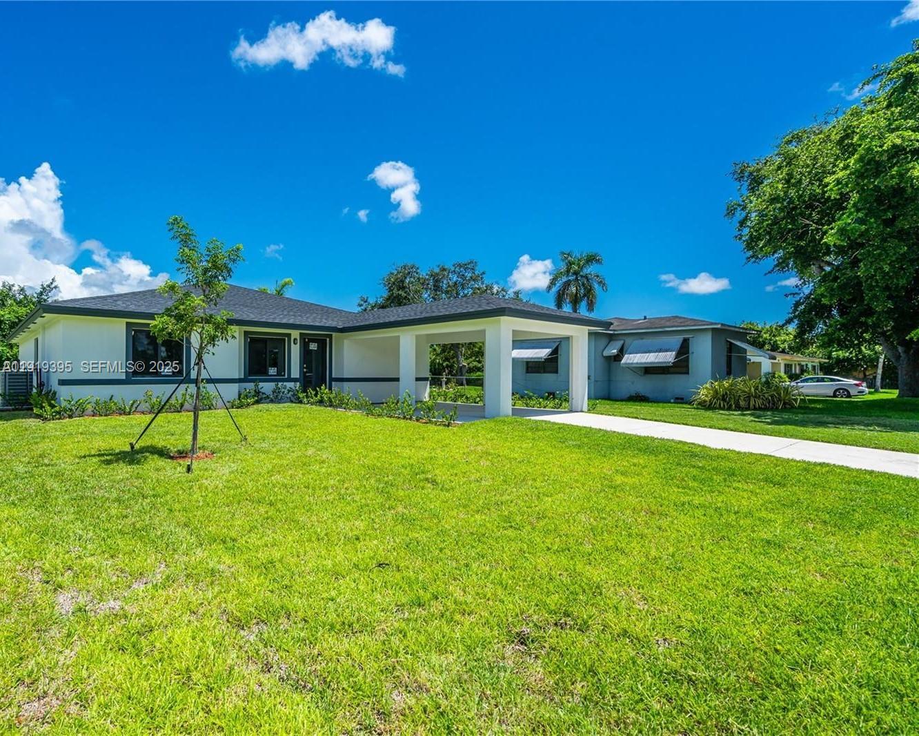 152 Northwest 18th Street Homestead, FL 33030 - Photo 3 of 11 a porch with a table and chairs under an umbrella