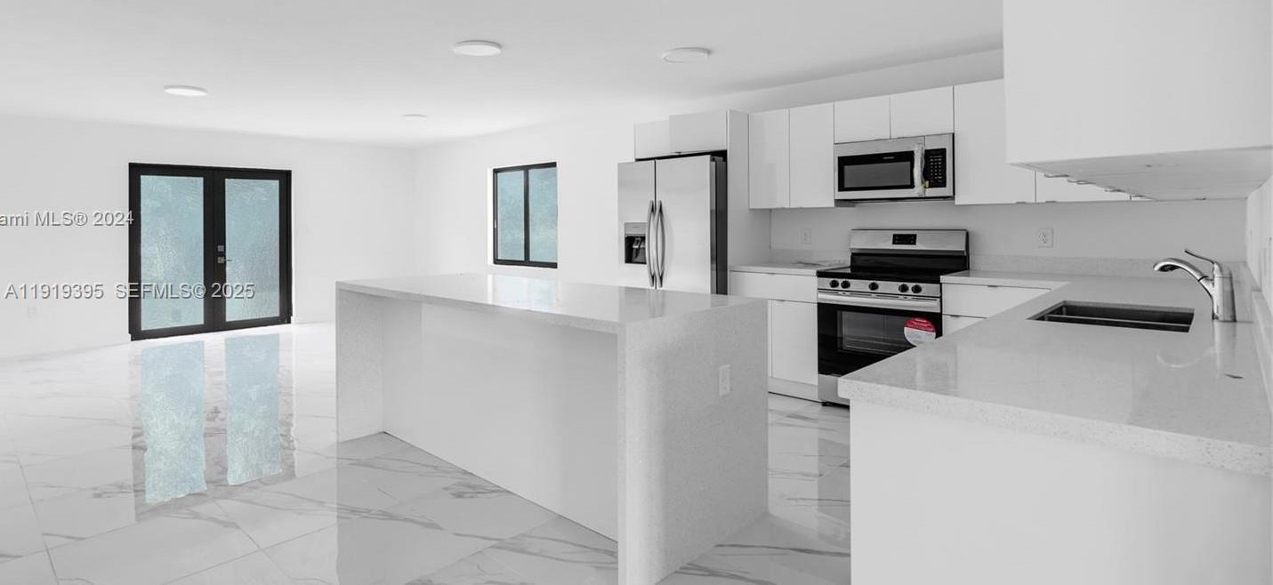 152 Northwest 18th Street Homestead, FL 33030 - Photo 5 of 11 a kitchen with a sink a stove and refrigerator