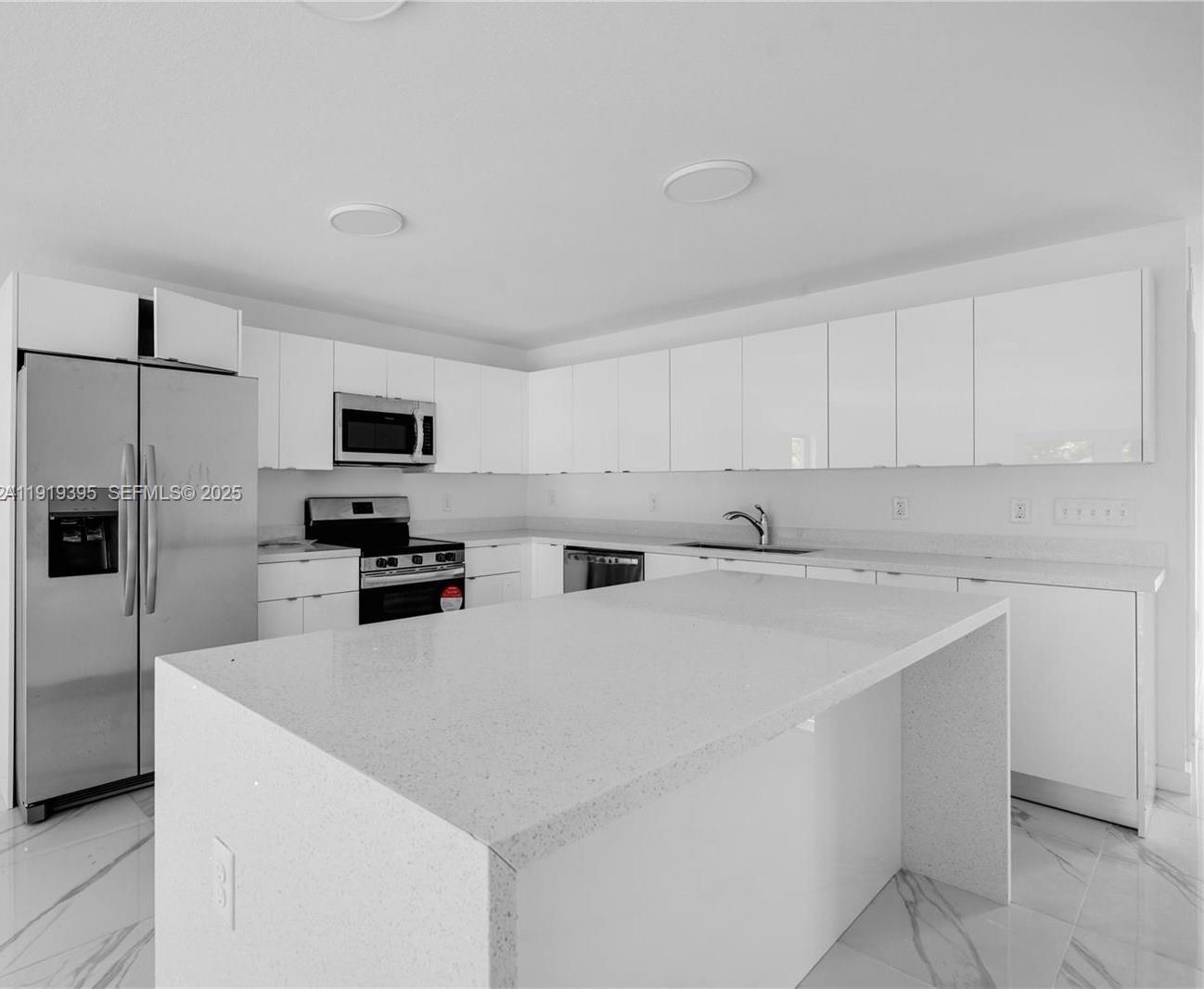 152 Northwest 18th Street Homestead, FL 33030 - Photo 6 of 11 a kitchen with stainless steel appliances a refrigerator sink and microwave