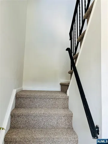 a view of staircase with white walls and railing