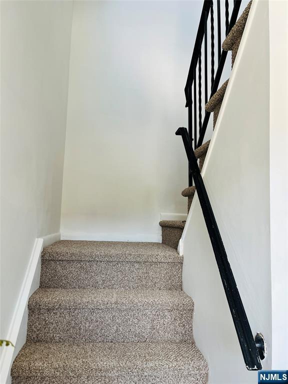 26 Pilgrim Court, Unit SECOND Bloomfield, NJ 07003 - Photo 11 of 12 a view of staircase with white walls and railing