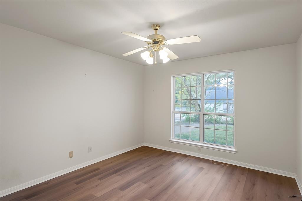 3133 Chimney Hill Drive Waco, TX 76708 - Photo 13 of 29 an empty room with wooden floor chandelier fan and windows