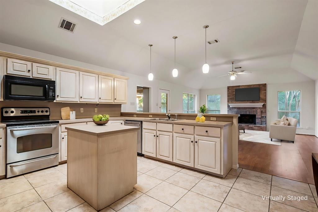 3133 Chimney Hill Drive Waco, TX 76708 - Photo 25 of 29 a kitchen with stainless steel appliances granite countertop a stove top oven a sink a counter top space cabinets and a view of living room